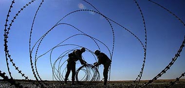Soldiers of US Army's 4th Infantry Division roll out razor wire