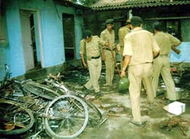 Policemen examine a residential house after 19 tea garden workers were burnt to death in Jalpaiguri on Thursday. 