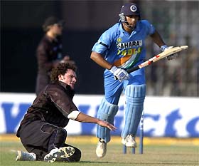 Indian opener VVS Laxman runs between the wickets as New Zealand bowler Kyle Mills lies on the ground after spilling a catch