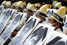 South Korean workers hold portraits of their colleagues
