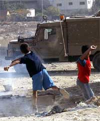 Palestinian youths hurl stones at an Israeli army