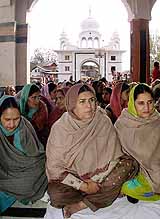 Sikh women listen to prayers at a Gurdwara on the occasion of Gurpurb, in Srinagar 