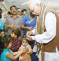 Deputy Prime Minister L.K. Advani distributes sweets among children on his 76th birthday in New Delhi