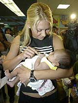 Russian tennis player Anna Kournikova holds a baby girl at a hospital in Pattaya