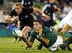 New Zealand's Justin Marshall runs as South Africa's Joost van der Westhuizen dives for the ball 