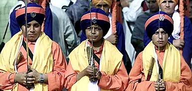 Sikh children, dressed in traditional attire, participate in a religious procession to mark Gurpurb 