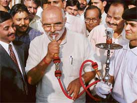 Union Labour Minister Mr Sahib Singh Verma smokes the fruit-flavoured hookah at the Mr Beans Coffee outlet he inaugurated in Chandigarh