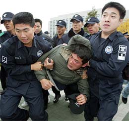 The police removes a farmer from the national assembly compound in Seoul on Monday. 