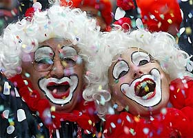Women dressed as clowns dance at the Cologne street carnival in Cologne, Germany