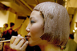 A model wearing a chocolate wig gets her make-up done before the Chocolate Show in New York 