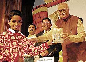 Deputy Prime Minister L. K. Advani presents a copy of the Hindi edition of 'Harry Potter' to 11-year-old Akhilesh Pandey, who reviewed the complimentary copy of the book and gave his comments, at the release of the book in New Delhi