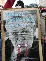 A Japanese student holds up a poster in protest against US Defence Secretary Donald Rumsfelds visit to Japan, near the US embassy in Tokyo on Friday.