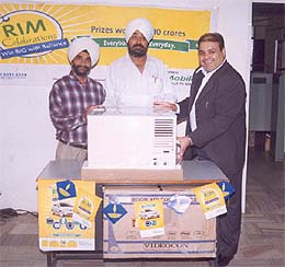 Mr Kapil Taneja of Reliance Infocomm hands over prizes to the winners of RIM celebrations offer
