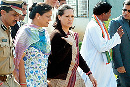 Opposition Leader and Congress Party President Sonia Gandhi walks along with unidentified officials during her election campaign in Chhattisgarhs Bhillai town 