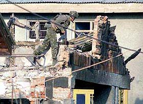 A soldier searches the debris of a house during a gun battle in Srinagar