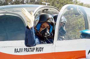 Union Civil Aviation Minister Rajiv Pratap Rudy wave to the spectators from the cockpit of an Indian Air Force HPT-32 aircraft before taking a ride to Tiruchirapalli 