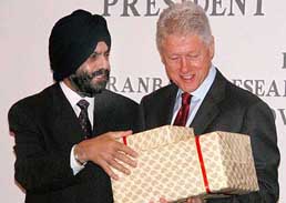 Bill Clinton receives mementoes presented to him by Ranbaxy CEO D.S. Brar after signing an agreement between the firm and the Clinton Foundation to reduce the price of AIDS drugs 