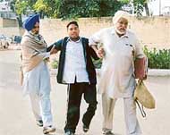 Satwinder Singh being helped by his father Darshan Singh (right) outside the office of the SSP Jagraon