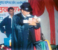 S.K. Sharma, magician, displays his tricks at Kumbh village during a cultural night organised on Friday