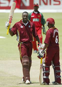 West Indies batsman Chris Gayle raises his bat after reaching his century