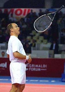 Prince Albert of Monaco flips his racket while playing a tennis doubles during the ATP Senior Tour of Champions