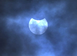 The partial solar eclipse is seen through clouds