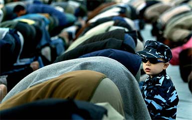 A boy dressed up in new Palestinian police outfit looks on during the last Ramzan prayer outside a mosque in Gaza city 