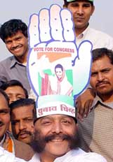 A Congress supporter wears a hat with the party symbol of the Congress imprinted on it at a rally in New Delhi on Thursday