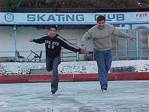 Two boys enjoy skating at an ice skating arena in Shimla on Thursday
