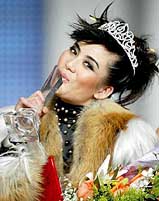 Wang Min, the newly selected Chinese best fashion model of 2003 kisses her trophy during an award ceremony of China International Fashion Week in Beijing on Wednesday