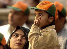 This small child supporter dons a cap with the BJP party symbol at an election rally in New Delhi