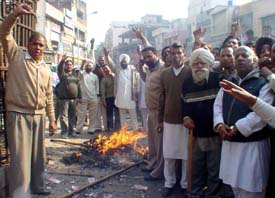 Congress workers led by DCC president Jagmohan Sharma burn the effigy of Mr Parkash Singh Badal 