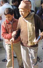 A ten-year-old child helps his grandfather to the polling booth