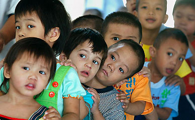 Young AIDS patients share a rare happy moment while queueing up for lunch at the Phyathai Babies Home Foundation in Bangkok