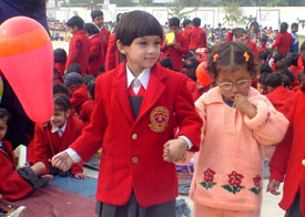 An LKG student of BCM Arya Model School takes a physically challenged student of Aashirwad around her school campus during an interaction on World Disabled Day