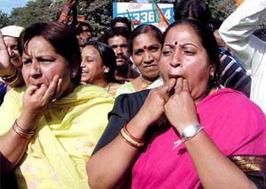 BJP supporters whistle following their party's triumph at the Madhya Pradesh Assembly election in Indore on Thursday