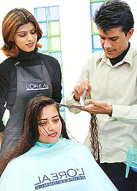 Creative Training Manager of L Oreal Mel Roy treats the hair of a city resident on Tuesday.