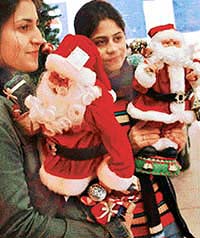 Imported Santas attract the fancy of city youngsters. 