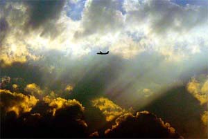 A plane flies as the sun sets in New Delhi on Monday