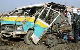 An Iraqi police officer inspects the remains of a bus at the scene of an explosion in Baghdad on Wednesday.
