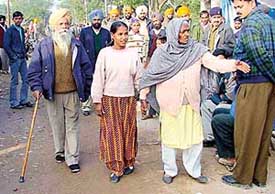 Ms Gurmeet Kaur and Mr Ujagar Singh on their way to cast their ballot for the panchayat poll at Khuda Alisher village