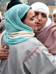Women embrace each other before leaving for the Haj pilgrimage