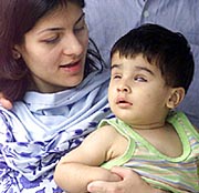 Mohammed Talha Shahzad sits with his mother, Kanwal Shahzad, in a hospital in Chennai