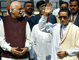 Deputy Prime Minister Lal Krishan Advani watches as Bal Thackeray (right) Shiv Sena chief, gestures after a press conference