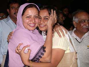 A Pakistani woman greets her relative who arrived from India by Pakistan International Airline's return flight from Mumbai at Karachi airport
