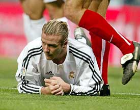 Real Madrids English player David Beckham lies on the pitch after a clash with a Real Murcia player