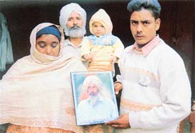 Ajit Singhs widow carrying his picture with her son and brother-in-law in Siahar