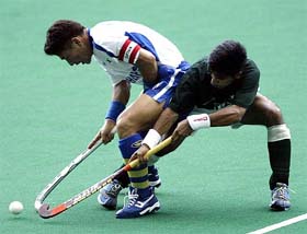 South Korea's Kim Jung Chul tries to dribble past Pakistan's Waseem Ahmed during their match at the Sultan Azlan Shah Cup Hockey tournament 