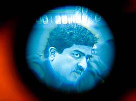 Nandan Nilekani, Chief Executive of Infosys Technologies, is seen on a viewfinder of a video camera as he presents the company's third-quarter results in Bangalore