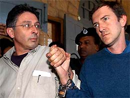 French journalists, Marc Epstein and Jean-Paul Guilloteau, leave the district court after being sentenced